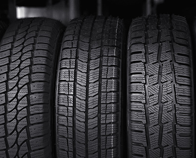 Vue en coupe illustrée d'un pneu montrant les différences de gomme et structure entre un modèle haut de gamme et économique