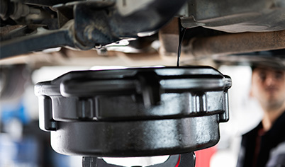 Technicien professionnel effectuant une vidange moteur rapide et efficace